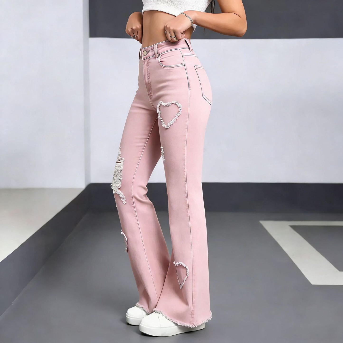 Women's high waist flared denim jeans featuring embroidery and ripped details, shown from the back to highlight the fit and d