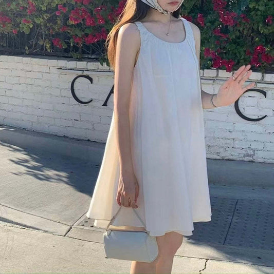 Sleeveless pleated suspender midi dress in Mori style, shown in soft cotton fabric with a flowing skirt and wide waist, available in beige and black for casual everyday wear
