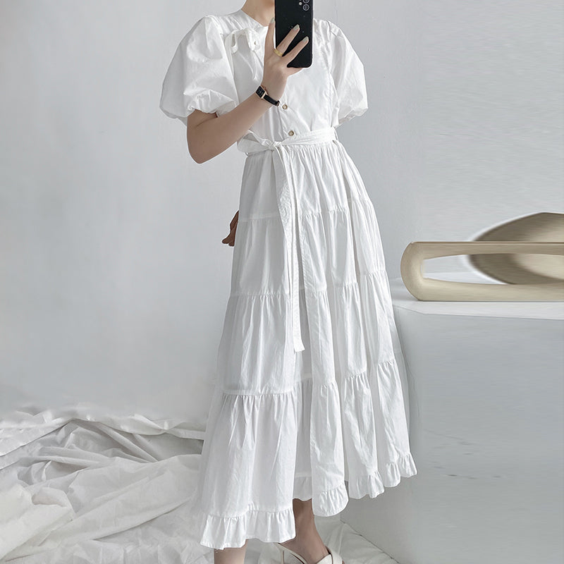 Woman wearing an elegant high-waist puff sleeve cotton dress with a round neckline, styled for a casual yet polished everyday look