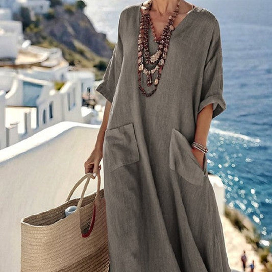 Woman wearing a floral kaftan maxi dress with a V-neck, loose fit, and patch pockets, styled for a casual warm-weather look