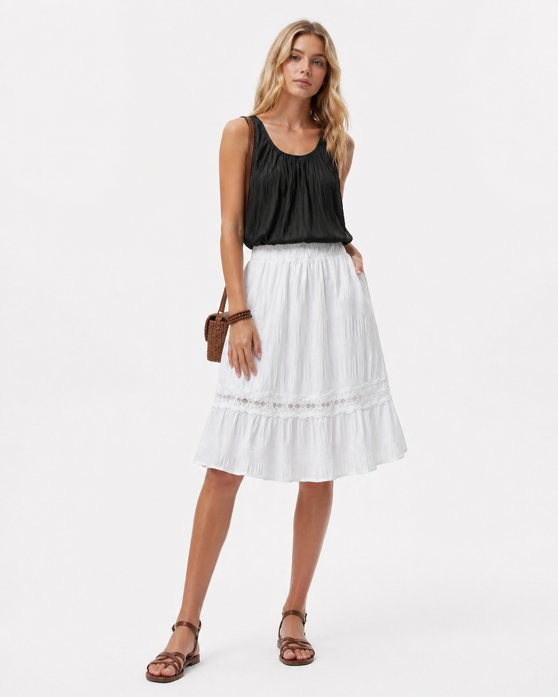 A ruffle pleated midi skirt in classic black with an elastic waist, styled for casual resort and everyday wear, featuring a feminine pleated silhouette and minimalist aesthetic.