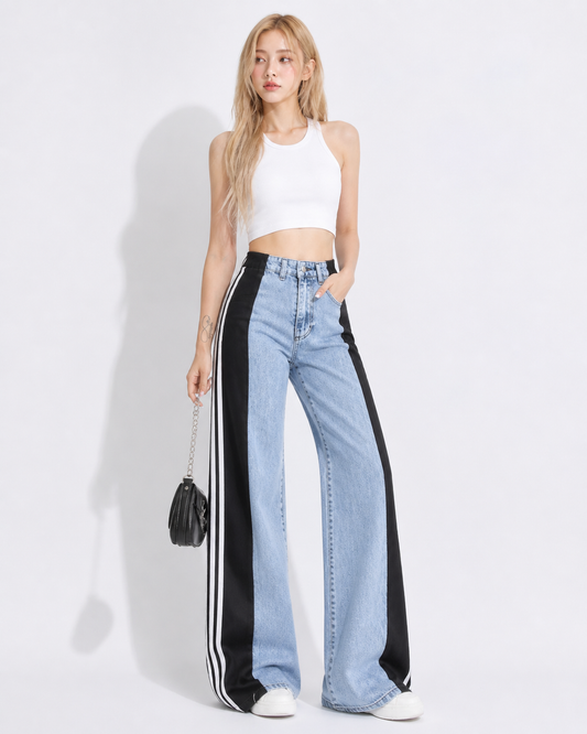 Woman wearing high-waist wide leg denim pants with stripe patchwork detail in a casual streetwear outfit, featuring an elastic waistband and bold fashion-forward silhouette