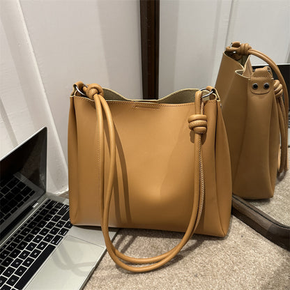 Women's PU leather retro bucket crossbody tote bag in a neutral tone, shown from the side to highlight the strap and structur