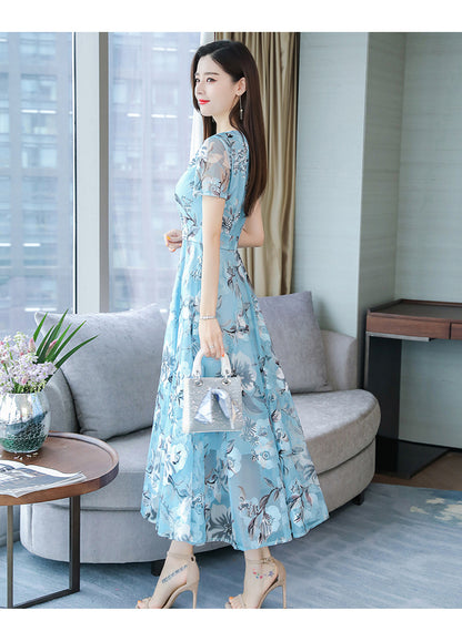 Plus size floral midi dress with V-neck and short sleeves, shown from the back in a vibrant summer print