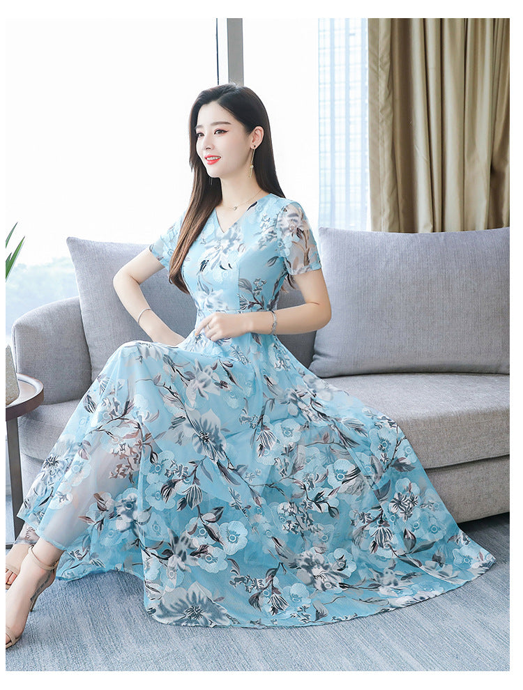 Plus size floral midi dress with V-neck and short sleeves, shown from the back in a vibrant summer print