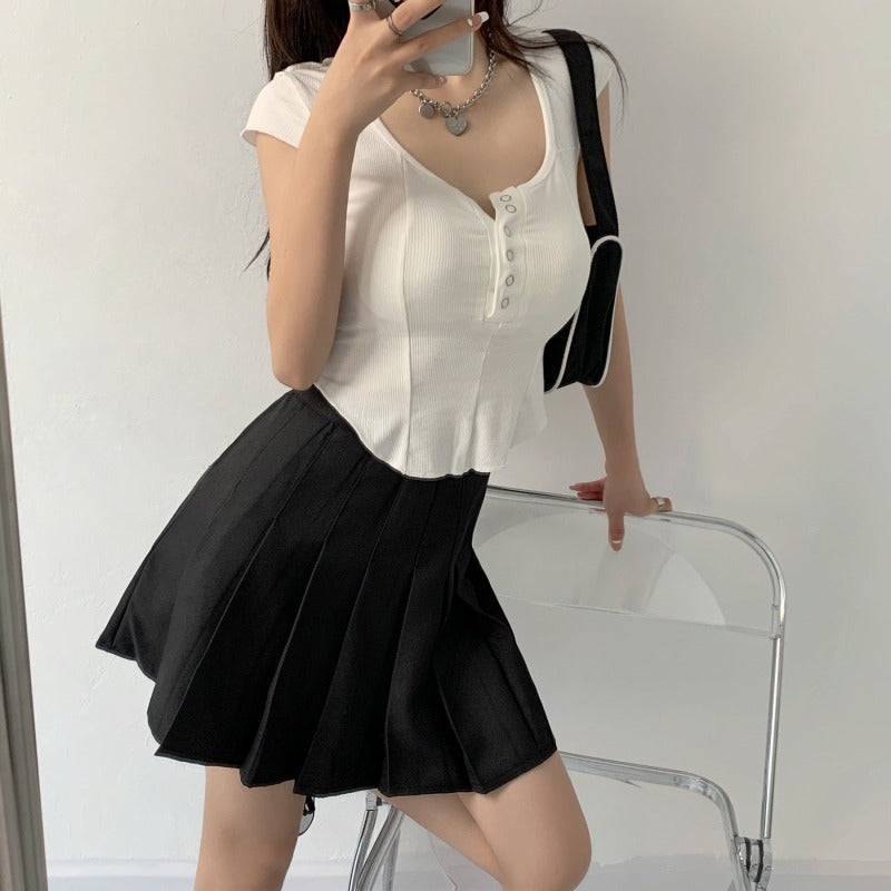 Black high waist pleated mini skirt with A-line flared silhouette, shown from the front on a model