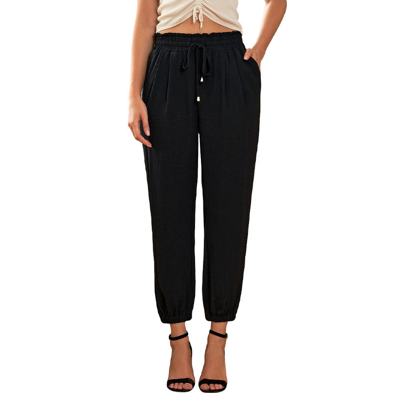 Women's high waist flared trousers with side pockets shown from the front, featuring a wide-leg silhouette in a solid color
