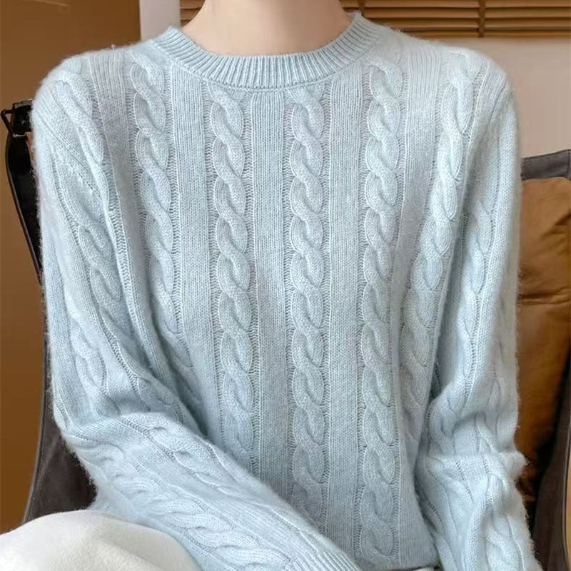 Women's loose cable-knit crewneck sweater in merino wool blend, shown from the back to highlight the textured knit pattern.