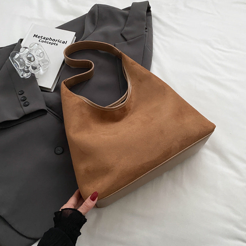 Women's suede tote shoulder bag with magnetic snap closure, shown from a side angle highlighting the soft texture and structu
