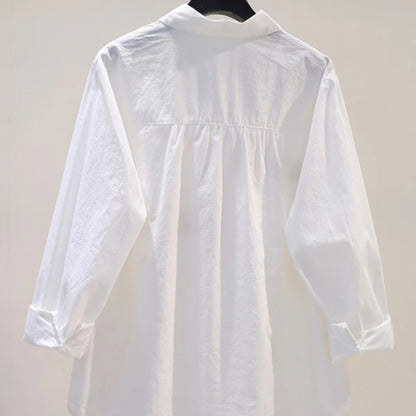 White loose fit cotton blouse with embroidered cartoon detail, shown from a close-up angle highlighting the embroidery design