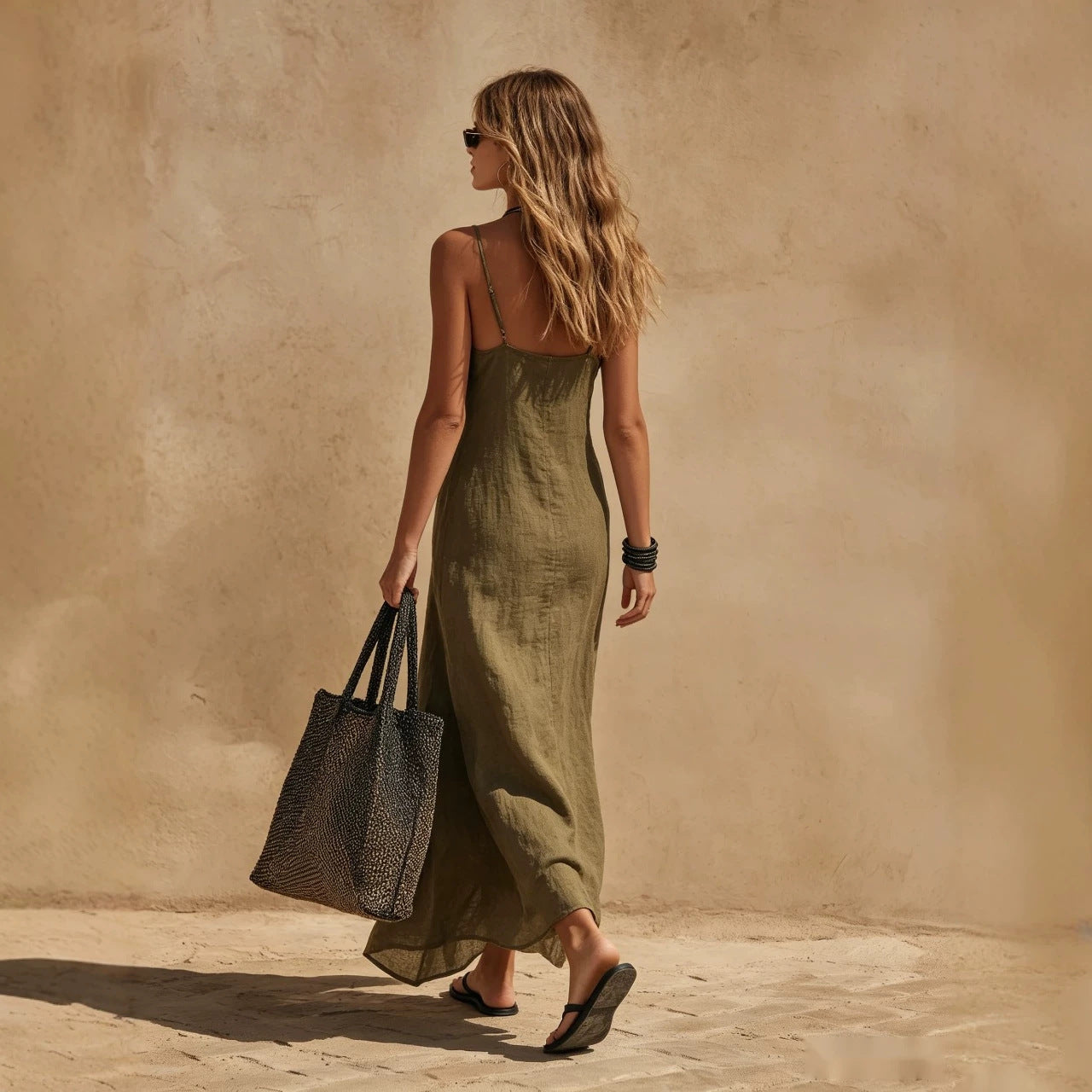 Loose sleeveless slip dress in a relaxed fit, side view showing the minimalist silhouette and flowing resort-style drape