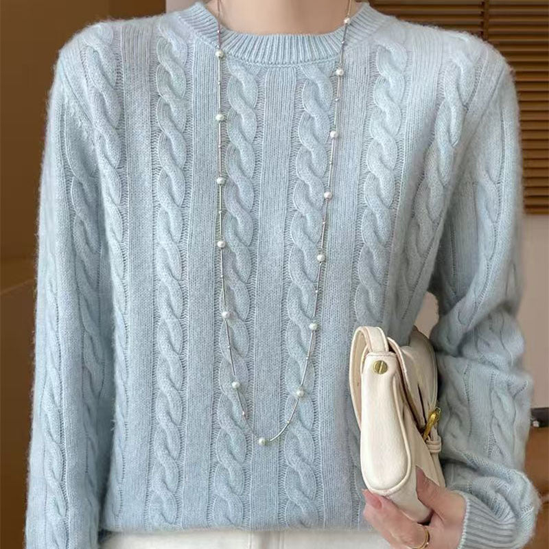 Women's loose cable-knit crewneck sweater in merino wool blend, shown from the back to highlight the textured knit pattern.