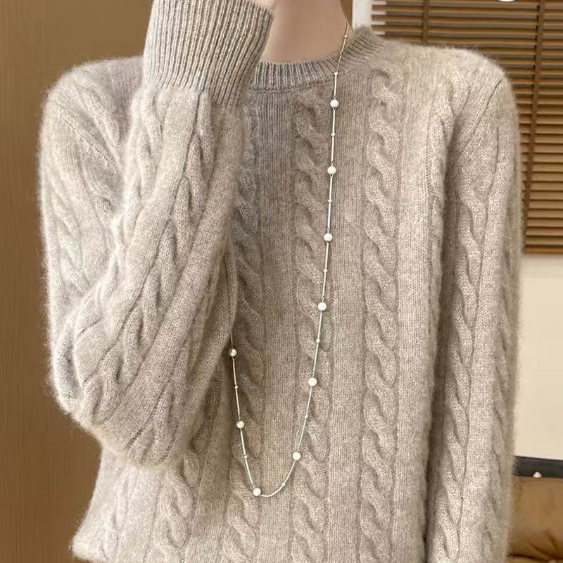 Women's loose cable-knit crewneck sweater in merino wool blend, shown from the back to highlight the textured knit pattern