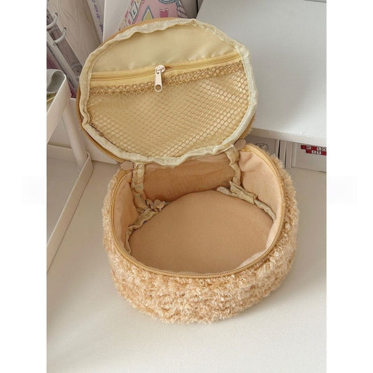 Oval lambswool cosmetic pouch with 3D bear head detail, shown from the side to display plush texture and zipper closure