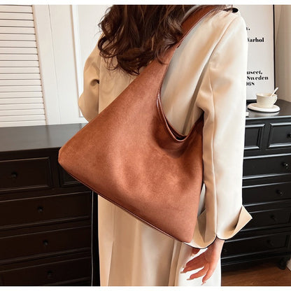 Women's suede tote shoulder bag with magnetic snap closure, shown from a side angle highlighting the soft texture and structu