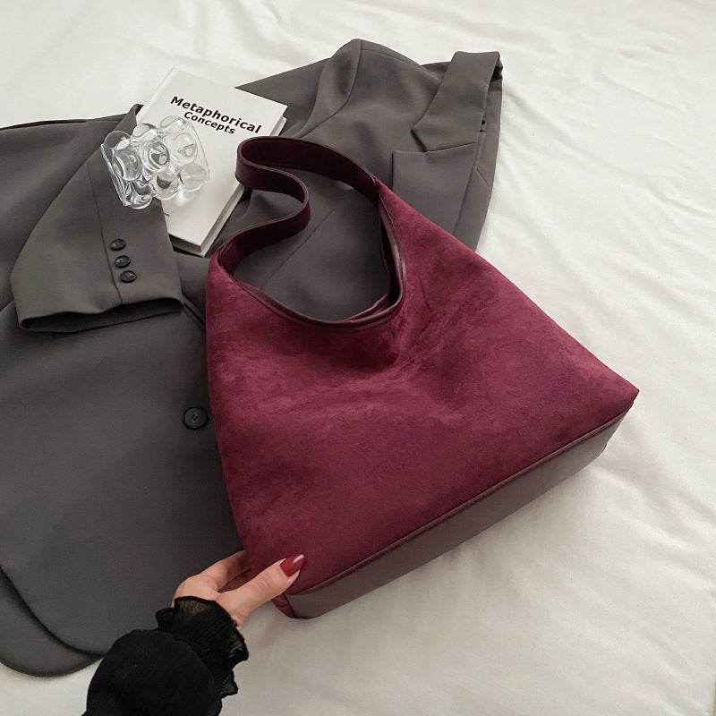 Women's suede tote shoulder bag with magnetic snap closure, shown from the side to highlight texture and strap length