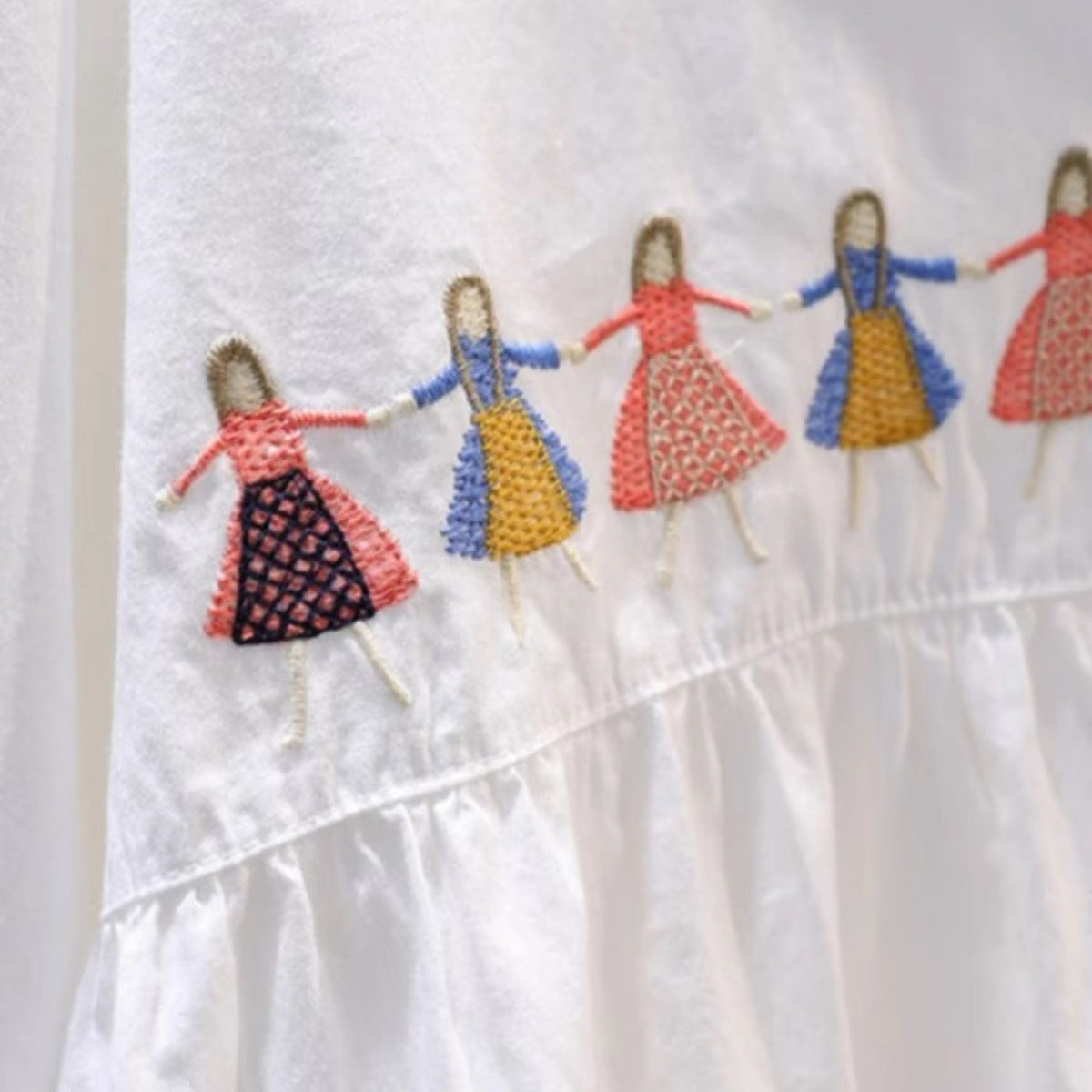 White loose fit cotton blouse with playful embroidered cartoon detail, shown from the back