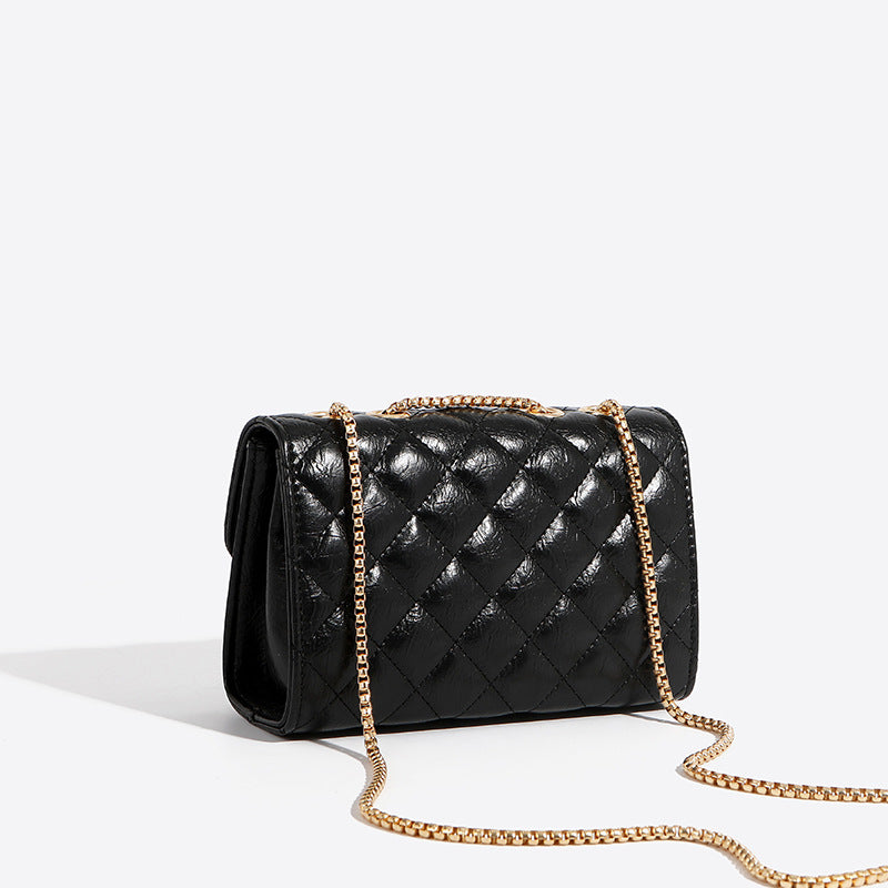 Minimalist PU crossbody bag with gold chain strap, shown from the side to highlight slim profile and structured silhouette.