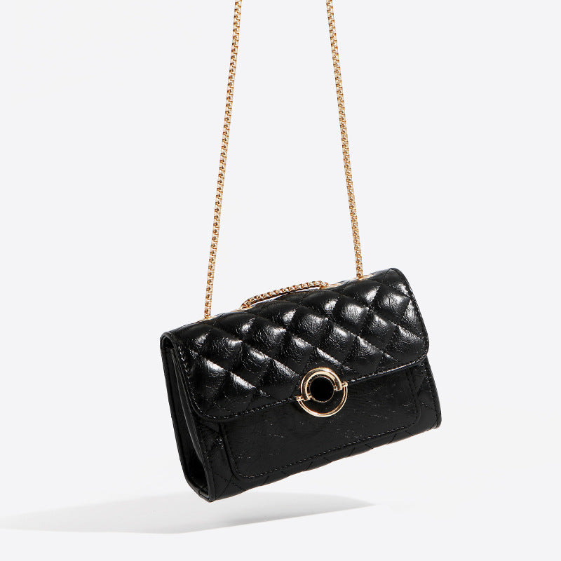 Small black PU leather crossbody bag with gold chain strap, shown from the front on a neutral background.