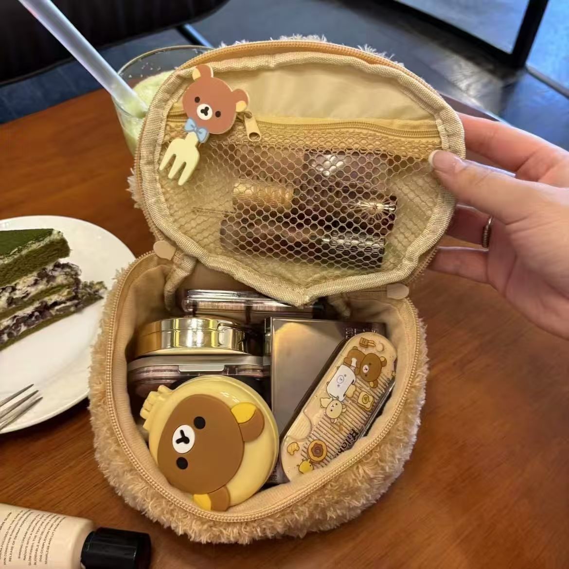 Oval lambswool cosmetic pouch with a 3D bear head detail, shown from the front in a soft plush finish