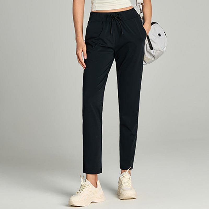 Women's loose straight-leg cropped pants with elastic drawstring waist, shown in a relaxed casual style